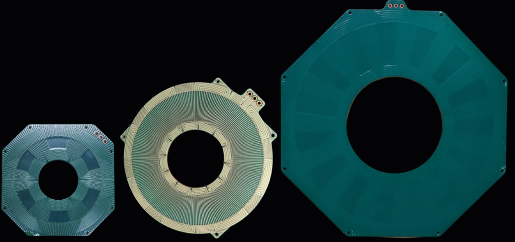 3 different sized PCB Stators on black background